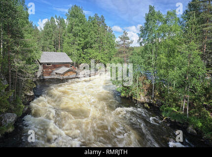 Ancien moulin à eau le long de l'évolution rapide des rapides de Myllykoski au Parc National d'Oulanka à Kuusamo, Finlande. La vue est d'un pont suspendu sur la riv Banque D'Images