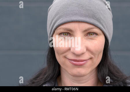 Portrait of smiling young woman wearing hat beanie gris. Banque D'Images