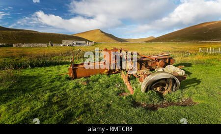 En regardant vers l'ouest sur Foula, Shetland vers Da Sneug au loin avec quelques vieux équipements agricoles rouillés au premier plan Banque D'Images