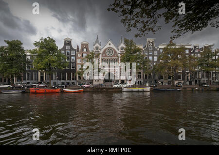 Vue sur le canal de canal typique maisons et bateaux à Amsterdam, Pays-Bas le jour un ciel couvert avec un ultra grand angle Banque D'Images