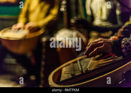 Man's hands playing kalimba avec des musiciens jouant des instruments africains floue sur scène Banque D'Images