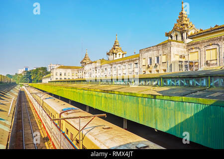 L'ancien train arrive au terminal de la gare centrale de Yangon, son bâtiment principal est visible sur l'arrière-plan, le Myanmar. Banque D'Images