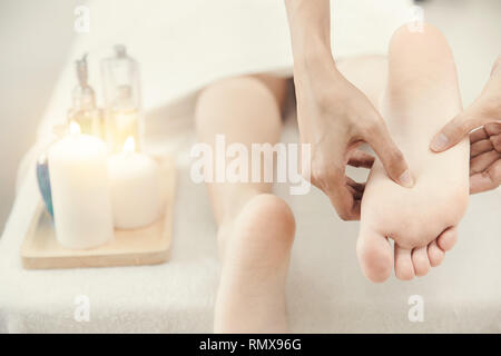Les femmes massage des pieds pieds en thérapie spa relax et doux ton propre livre blanc. Banque D'Images