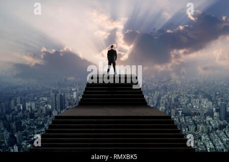 Succès et leader concept, businessman in suit debout sur escalier et à la ville avec plus de lumière du soleil Banque D'Images