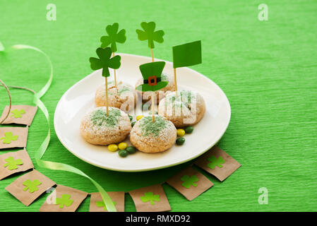 Happy St Patrick's Day. Des biscuits avec drapeau irlandais sur la table verte Banque D'Images