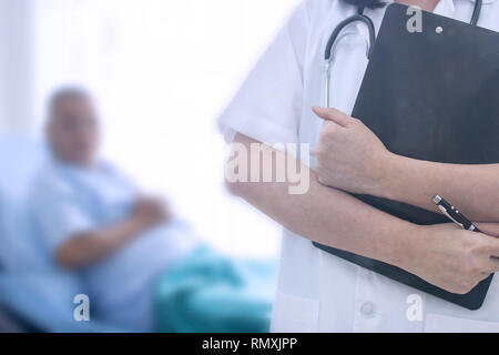 Doctor holding document file avec ancien patient portant sur fond de lit Banque D'Images