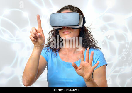 Femme victime d'un environnement virtuel alors qu'elle voit les graphiques simulées sur une paire de lunettes de réalité virtuelle avec une expression grave faisant Banque D'Images