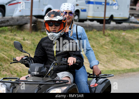 Deux jeunes femmes équitation un quad/ATV sur la route Banque D'Images