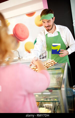 Vendeur de confiseries montrant nice sur la plaque de cookies Banque D'Images