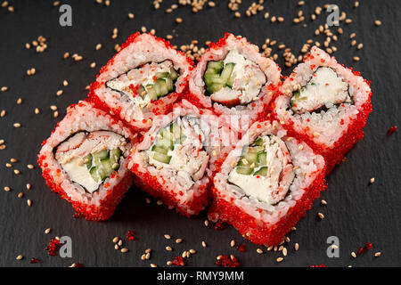 Vue de dessus du rouleau de Californie à la viande de crabe, concombre et fromage à la crème. Uramaki Sushi recouvert d'oeufs de poisson volant rouge. Banque D'Images