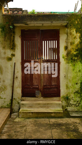 Une vieille porte en bois menant à un corridor extérieur dans la liste UNESCO vietnamiens du centre ville de Hoi An Banque D'Images