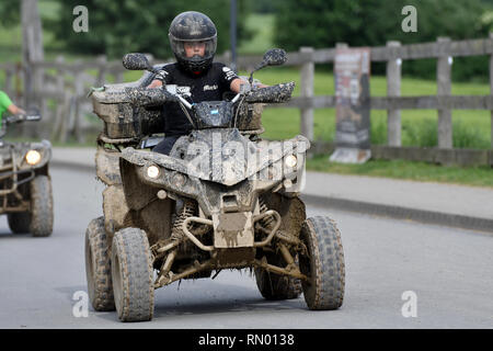 Un jeune garçon monté sur un quad/ATV sur la route Banque D'Images