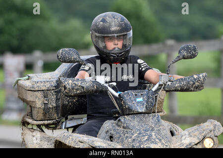 Un jeune garçon monté sur un quad/ATV sur la route Banque D'Images