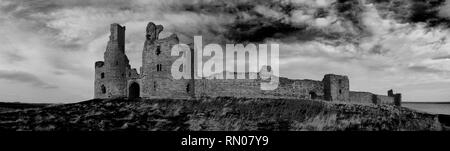 Panorama du château de Dunstanburgh, Northumberland, Angleterre dans le graphique noir et blanc. Banque D'Images