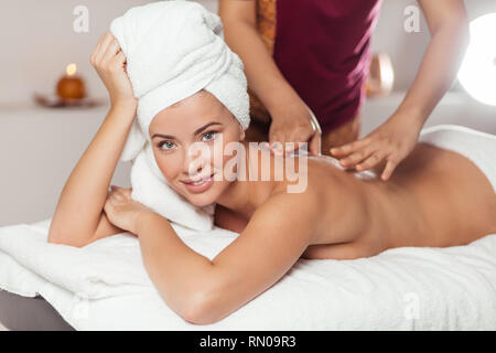 Femme en uniforme rouge faire un massage pour une fille dans la clinique. close up side view photo Banque D'Images