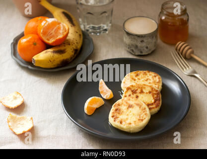 Petit déjeuner végétarien de quark des crêpes au miel, de fruits et de café avec du lait. De style rustique, selective focus. Banque D'Images