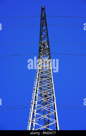 Vue en perspective d'une tour de transmission à haute tension contre fond de ciel bleu. Pylône de l'électricité en Allemagne. Banque D'Images