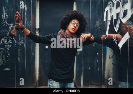 Les jeunes Afro-américains ou young businessman unpacking Pull col roulé noir et un foulard et avoir les cheveux foncés. Concept de la mode et élégant Banque D'Images