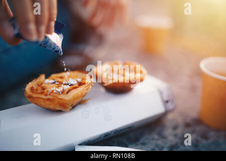 Gâteau portugais - Pasteis de Belem ou Nata. Pasteis de Belem avec du sucre en poudre et la cannelle. Lever du soleil dans l'arrière-plan Banque D'Images