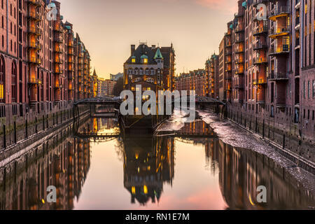 La Speicherstadt historique avec l'Wasserschloss à Hambourg, en Allemagne, après le coucher du soleil Banque D'Images