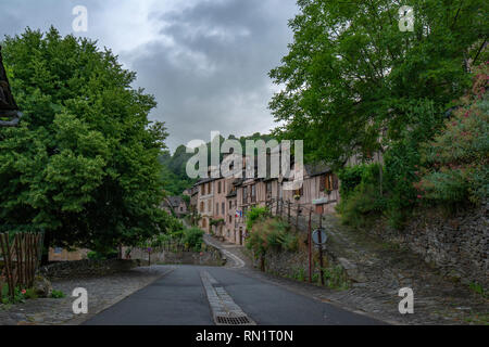 Conques, Midi Pyrénées, France ; Juin 2015 : Pierre étroite typique rue du village de Conques décoré avec des plantes et des fleurs dans leurs maisons Banque D'Images