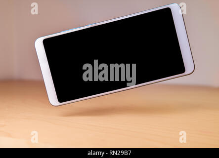 Smartphone ou flottante sur une table en bois en lévitation Banque D'Images