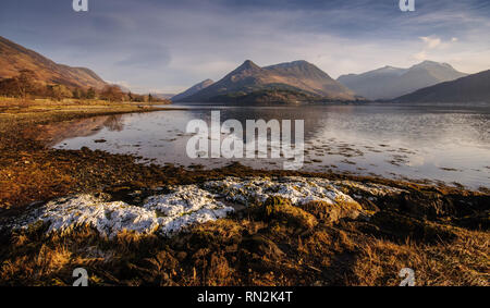 La forme distinctive de Pap Glencoe mountain se reflète dans l'eau calme de Loch Leven, un fjord-comme l'entrée de l'océan Atlantique, sur une claire wint Banque D'Images