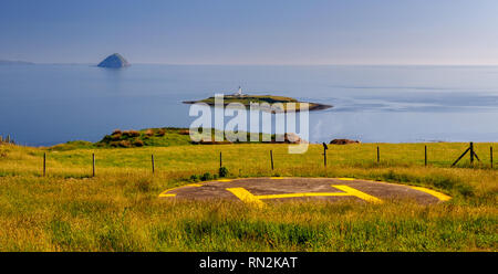 Les îles d'Ailsa Craig et Pladda s'élèvent sur les eaux de l'estuaire de la Clyde, en vue d'une falaise sur l'héliport de l'île d'Arran. Banque D'Images