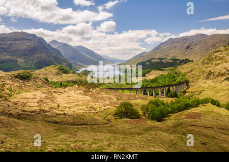 Le viaduc de Glenfinnan porte la ligne de chemin de fer West Highland haut au-dessus de la vallée à côté de l'Églefin Glen lochs et montagnes de l'Écosse. Banque D'Images