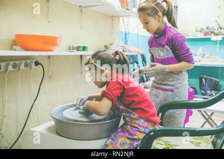 Deux petites filles, l'apprentissage créatif au potter atelier en art studio - Enfant façonner l'argile sur la roue de la poterie Banque D'Images