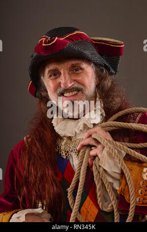 Portrait of smiling old redhead pirate holding rope, studio shot Banque D'Images