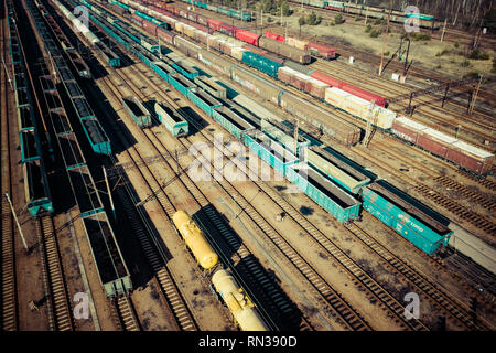 Vue aérienne de trains de marchandises colorées sur la gare. Wagons à marchandises sur le chemin de fer. L'industrie lourde. Scène conceptuelle industrielle avec des trains. Banque D'Images