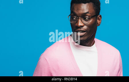 Jeune homme africain à la copie à l'espace. Bon à guy africains portant des lunettes sur fond bleu. Banque D'Images