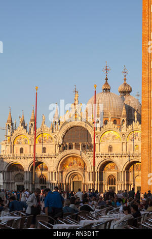 Piazza San Marco et de la Basilique de San Marco, La Cathédrale de St Marc, au coucher du soleil, Venise, Vénétie, Italie pendant la golden hour avec des touristes dans l'avant-plan Banque D'Images