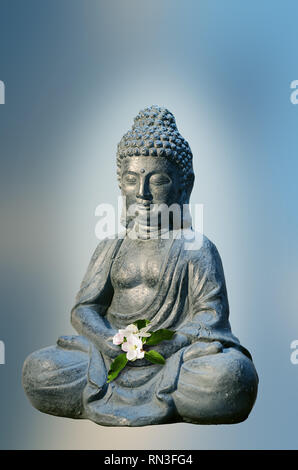 Statue de Bouddha est titulaire d'un pommier fleur dans les mains. Thème religieux modèle. Banque D'Images