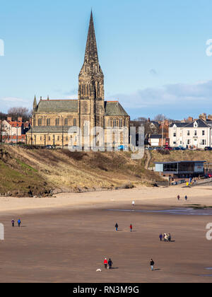 Tynemouth, England, UK - 4 Février 2019 : les gens à pied leurs chiens sur la grande plage de Tynemouth Longsands sur une journée d'hiver ensoleillée, avec Cullercoat Banque D'Images