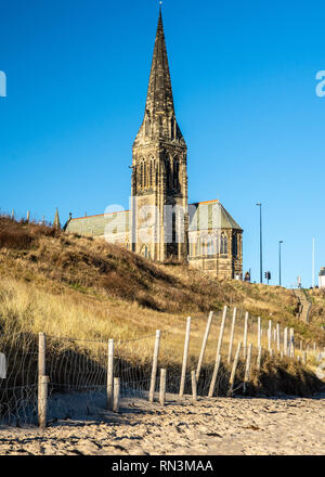 St George's Church spire s'élève au-dessus de la plage de sable de Tynemouth Longsands à Cullercoats à Tyneside. Banque D'Images