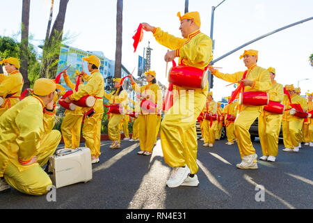 Le Falun Gong en jaune vif uniforme marching in parade de Noël sur Hollywood Boulevard à Los Angeles, Californie. Banque D'Images