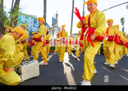 Le Falun Gong en jaune vif uniforme marching in parade de Noël sur Hollywood Boulevard à Los Angeles, Californie. Banque D'Images