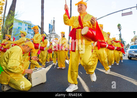 Le Falun Gong en jaune vif uniforme marching in parade de Noël sur Hollywood Boulevard à Los Angeles, Californie. Banque D'Images