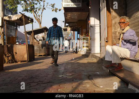 Un homme assis dans un magasin un bidi fumeurs entrée (Inde-style cigarette) sur un matin tôt dans Bhendi Bazar salon, Mumbai, Inde Banque D'Images