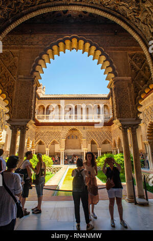 Les touristes à la Cour de la Jeunes filles au Royal Alcazar de Séville, un palais royal construit sur les terres d'un Abbadid forteresse musulmane, l'Espagne. Banque D'Images