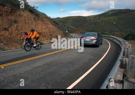 Profitez de la circonscription de cyclistes le long de la route de vent Marin Headlands parce qu'elle offre une excellente vue sur le Golden Gate Bridge et San Francisco. Banque D'Images