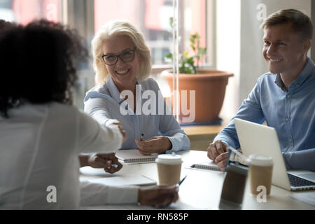 De businesswoman shaking hands with company client lors de réunion d'affaires Banque D'Images