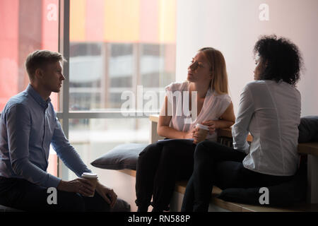 Collègues reposant assis dans la chambre bureau salon et de boire du café Banque D'Images