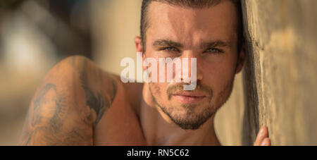 Bel homme de race blanche Model Posing sur la plage mur Banque D'Images