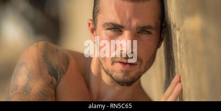 Bel homme de race blanche Model Posing sur la plage mur Banque D'Images