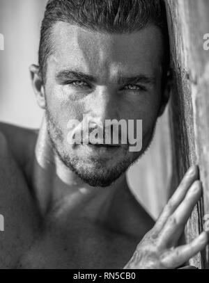 Bel homme de race blanche Model Posing sur la plage mur Banque D'Images