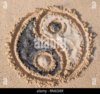 Symbole yin-yang est appelée et rempli de sable noir et blanc à Melasti beach à Bali, Indonésie Banque D'Images