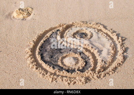 Symbole yin-yang est appelée et rempli de sable noir et blanc à Melasti beach à Bali, Indonésie Banque D'Images